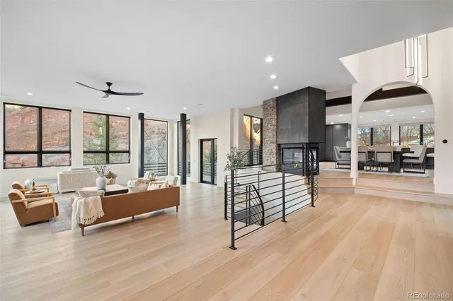 a living room with stainless steel appliances kitchen island granite countertop a table chairs and a sink