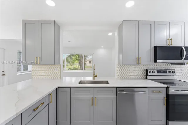 a kitchen with stainless steel appliances granite countertop a sink and a stove