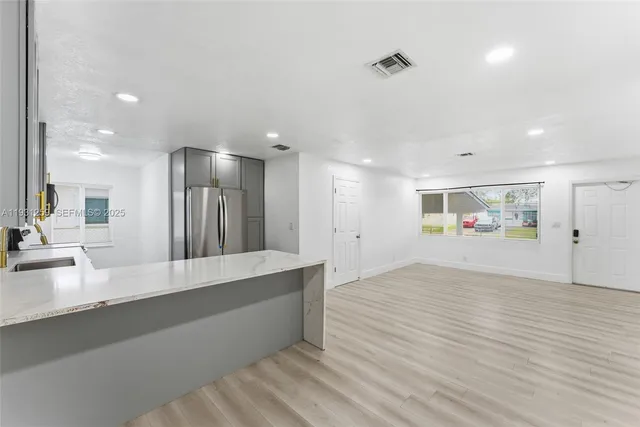 a view of a kitchen with a sink and wooden floor