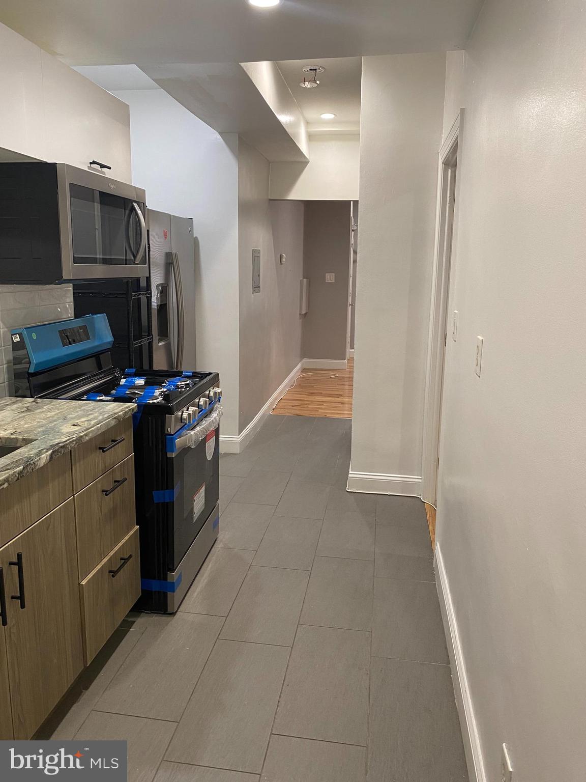 1122 Penn Street Northeast, Unit 1 Washington, DC 20002 - Photo 11 of 31 a kitchen with stainless steel appliances a stove a microwave and a refrigerator