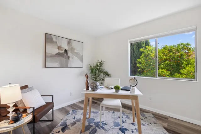 a workspace room with furniture and a potted plant