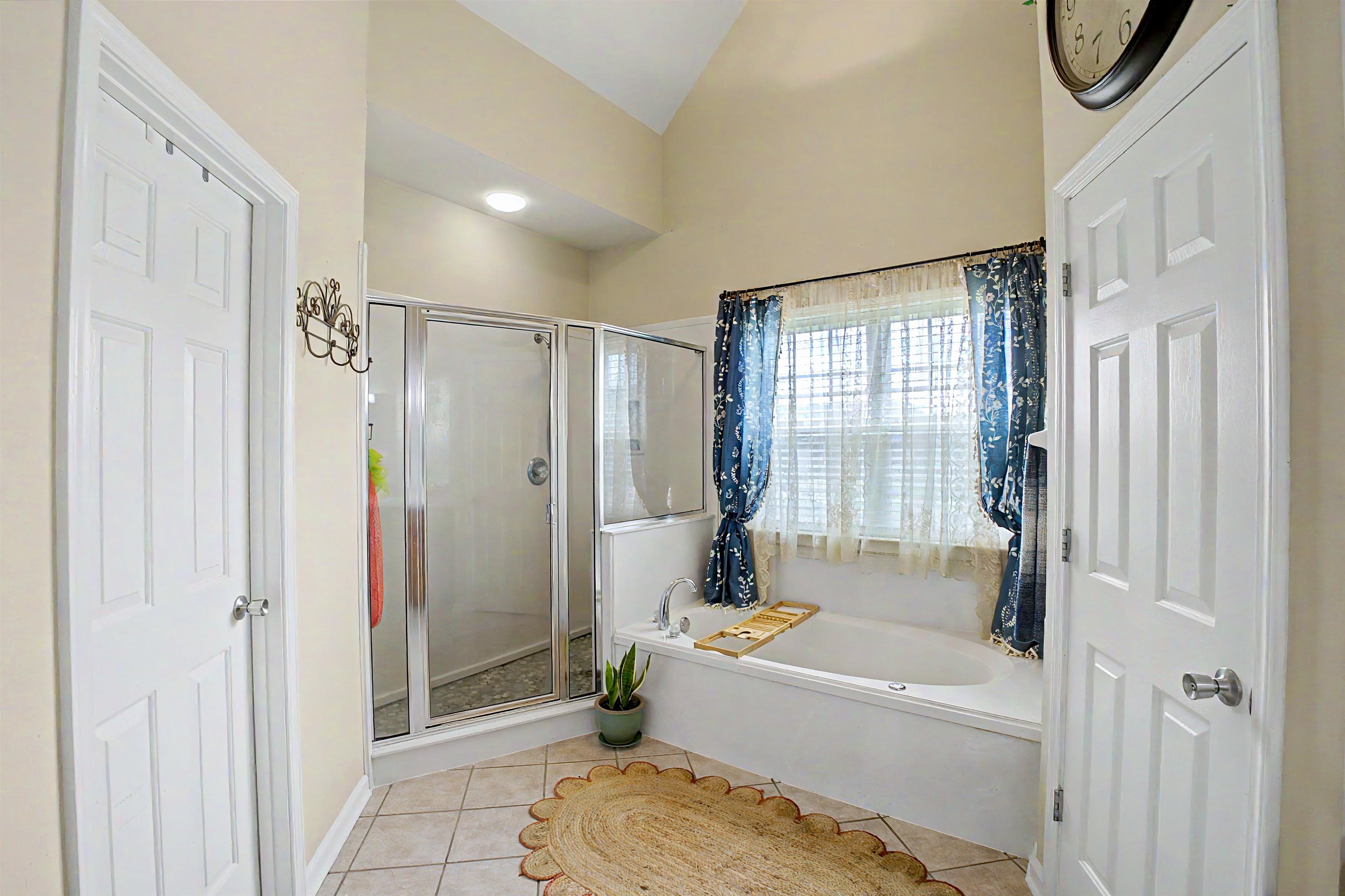 134 Rembert Drive Atoka, TN 38004 - Photo 25 of 38 Bathroom featuring a built-in soaking tub with privacy window, a separate glass-enclosed shower, tiled flooring, and vaulted ceiling