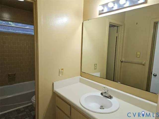 an empty room with wooden floor and chandelier fan