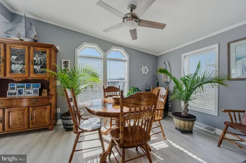a dining room with furniture potted plants and wooden floor