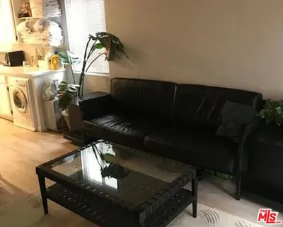 a view of a chair and table in backyard of the house