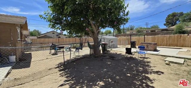 a view of a patio with a table and chairs with wooden fence