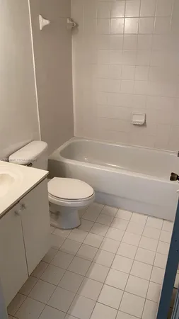 a bathroom with a granite countertop toilet a sink and a bathtub