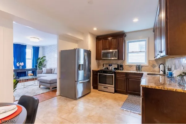 a kitchen with granite countertop stainless steel appliances a stove sink and cabinets