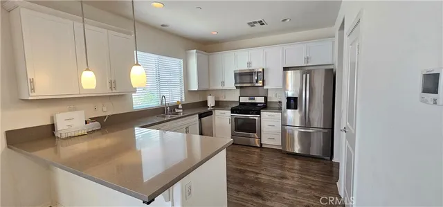 a kitchen with kitchen island a counter appliances a sink and cabinets