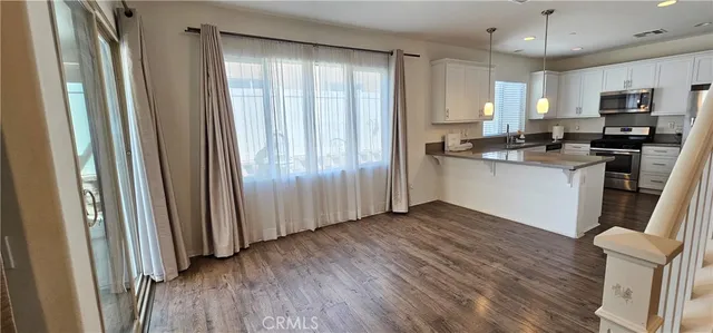 a kitchen with granite countertop stainless steel appliances a stove top oven and sink