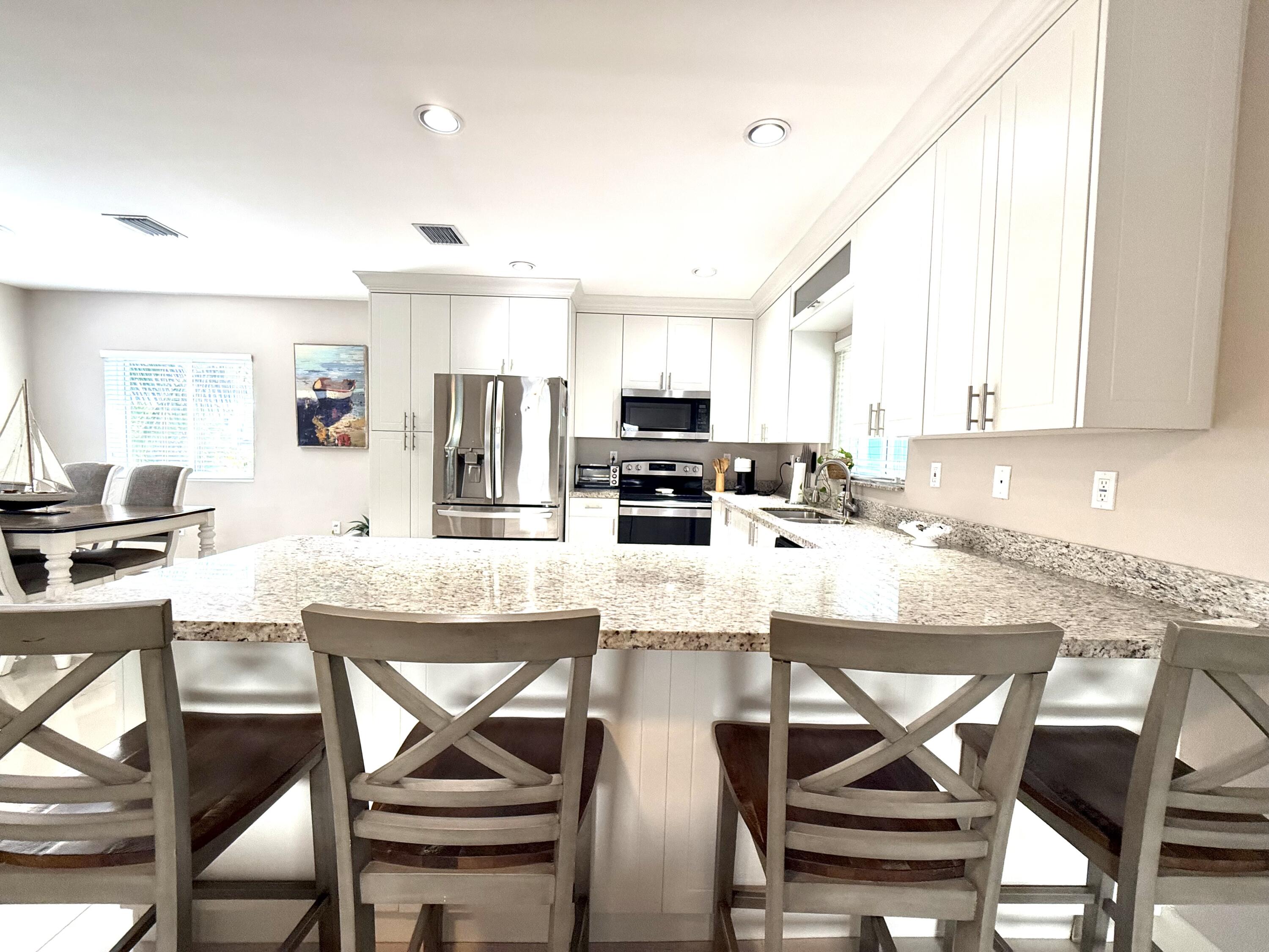 15 Lake View Drive Key Largo, FL 33037 - Photo 20 of 53 a kitchen with stainless steel appliances granite countertop a stove top oven a sink a dining table and chairs