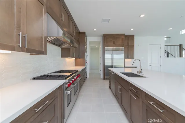 a kitchen with stainless steel appliances granite countertop a sink a stove and a refrigerator