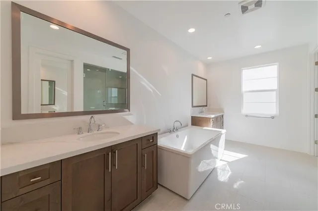 a en suite bathroom with a double vanity sink and a mirror
