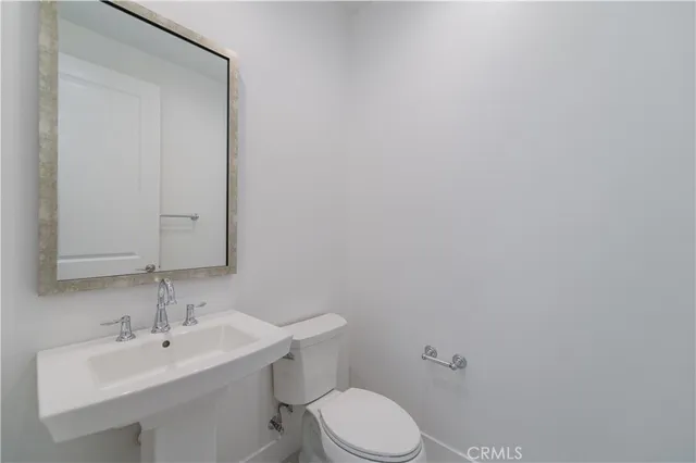 a bathroom with a sink vanity mirror and toilet