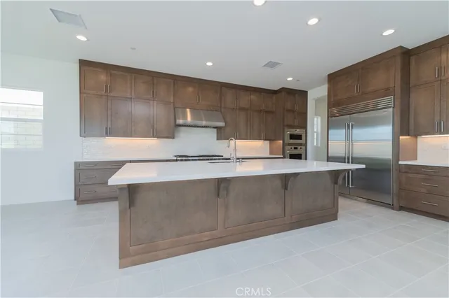 a kitchen with kitchen island a sink stainless steel appliances and cabinets