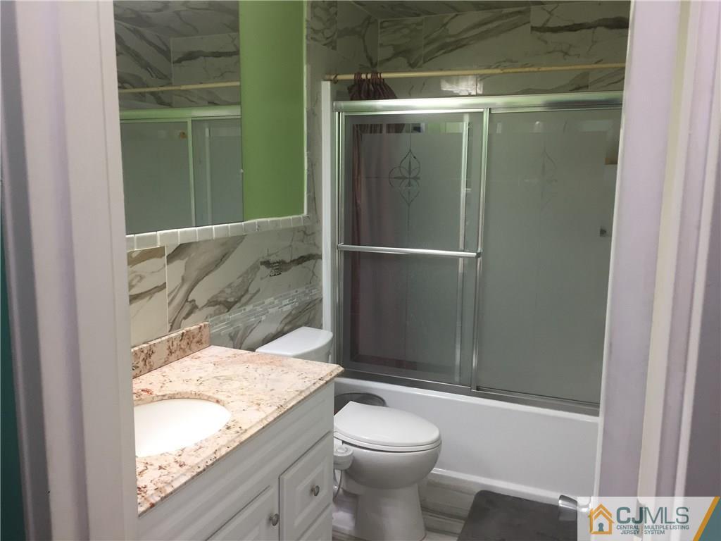 47 Blair Road Carteret, NJ 07008 - Photo 5 of 23 a bathroom with a granite countertop sink toilet and shower
