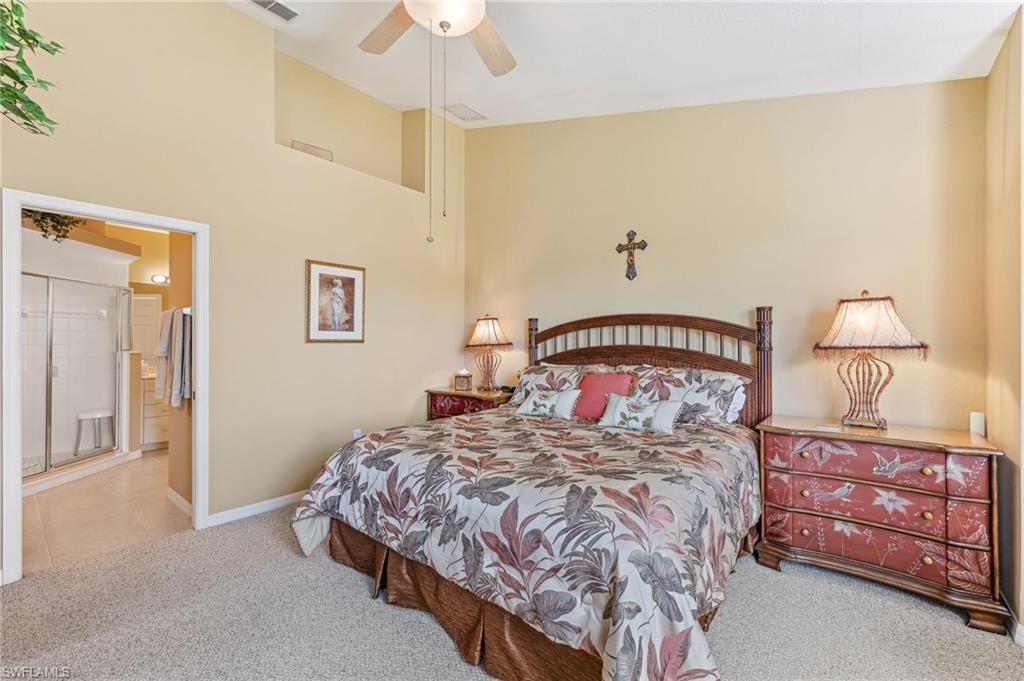 20051 Seagrove Street, Unit 1208 Estero, FL 33928 - Photo 13 of 25 a bedroom with a bed a lamp and a chandelier