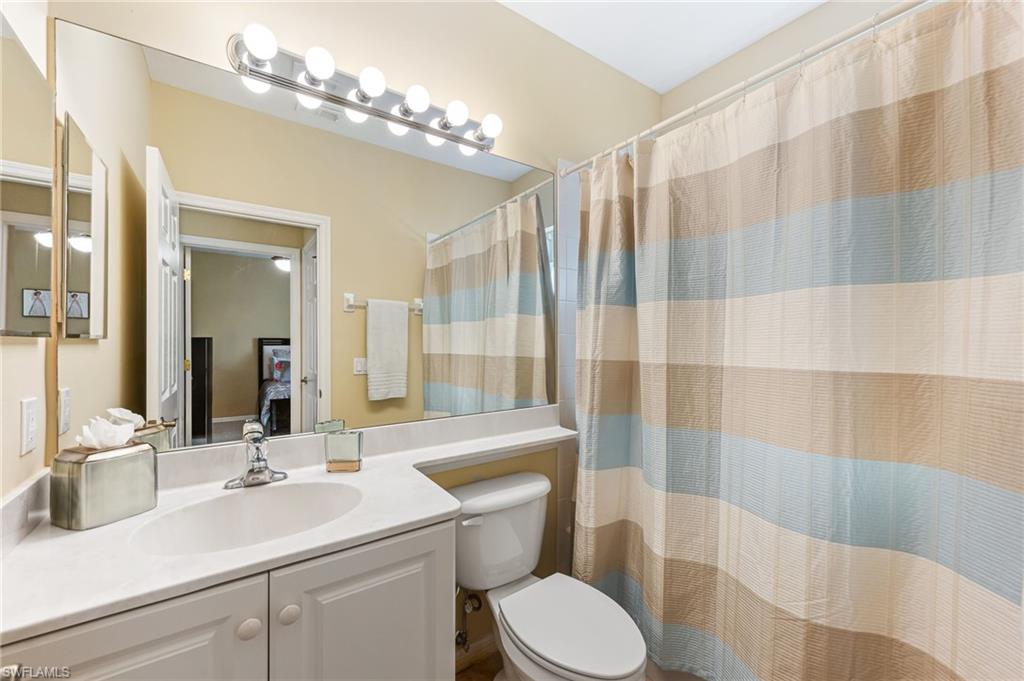 20051 Seagrove Street, Unit 1208 Estero, FL 33928 - Photo 18 of 25 a bathroom with a sink a toilet a mirror and shower