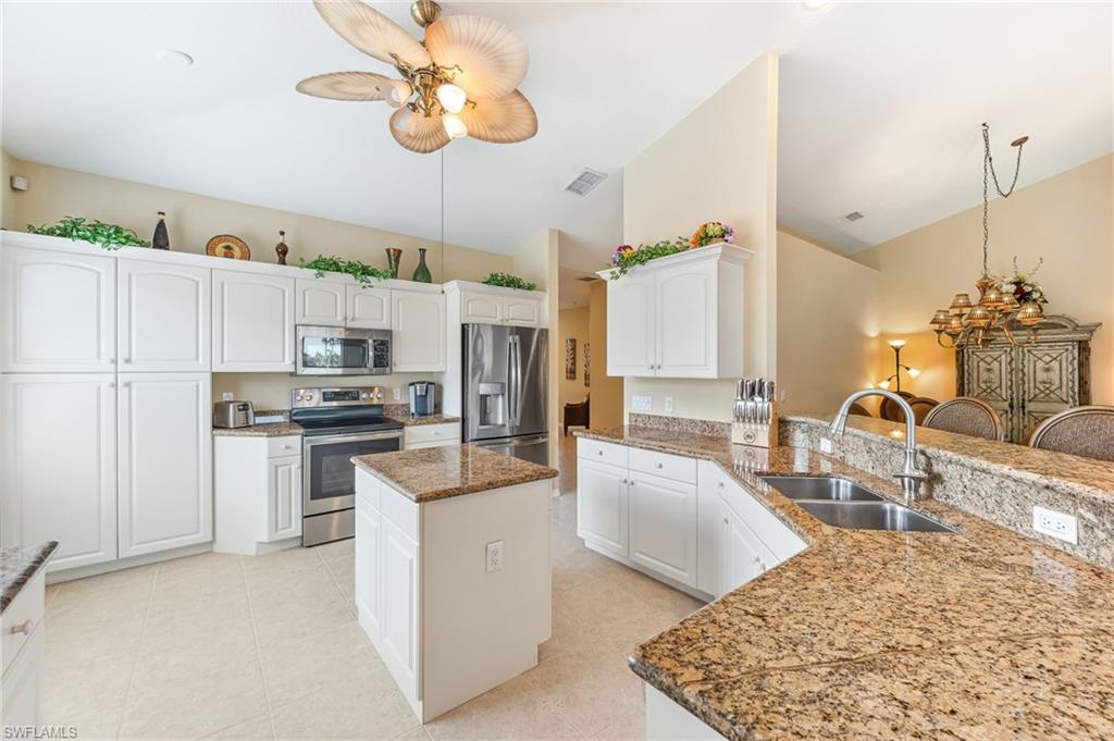 20051 Seagrove Street, Unit 1208 Estero, FL 33928 - Photo 6 of 25 a kitchen with stainless steel appliances granite countertop a sink stove and refrigerator