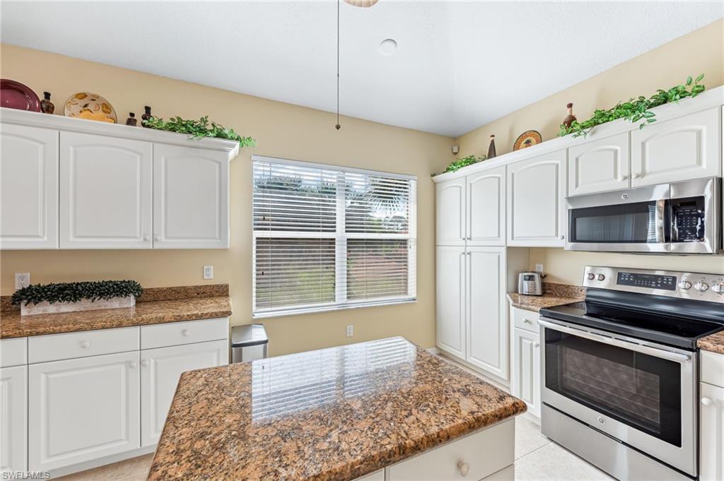 20051 Seagrove Street, Unit 1208 Estero, FL 33928 - Photo 9 of 25 a kitchen with stainless steel appliances granite countertop a stove a sink and a refrigerator
