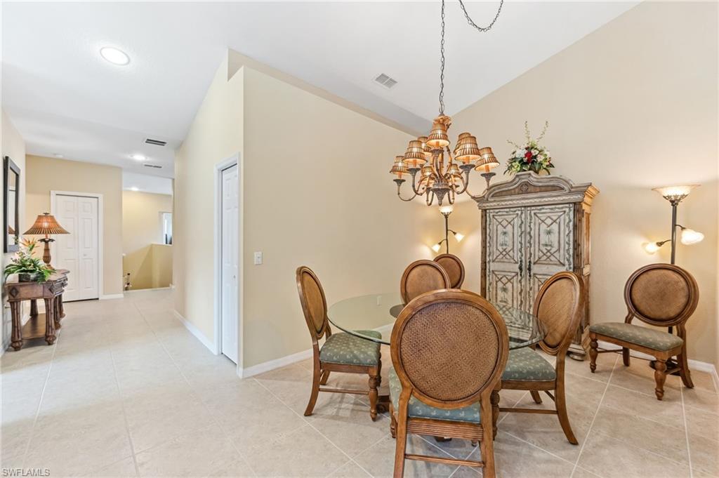 20051 Seagrove Street, Unit 1208 Estero, FL 33928 - Photo 10 of 25 a view of a dining room with furniture wooden floor and chandelier