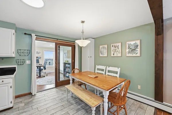 a living room with a table chairs and wooden floor