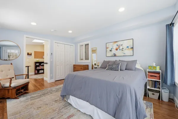 a spacious bedroom with a bed a table and painting on the wall