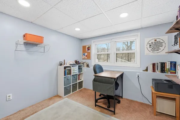 a view of a workspace with furniture and a window