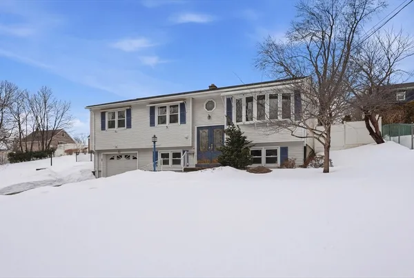 a front view of a house with a yard covered in snow