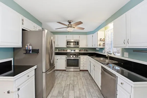a kitchen with stainless steel appliances a stove a sink and a refrigerator