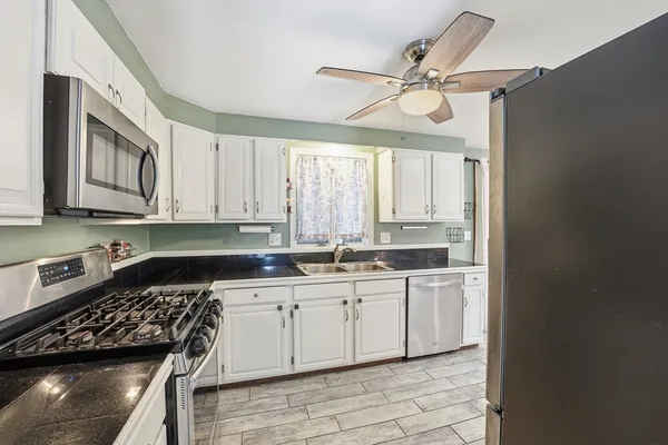 a kitchen with stainless steel appliances a stove a sink and cabinets