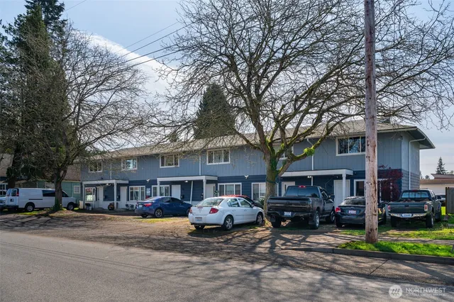a front view of a building with cars parked