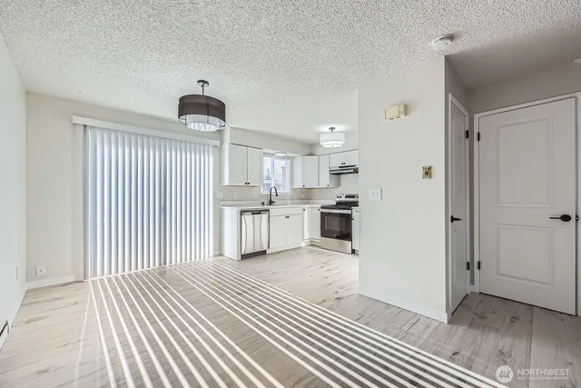 a view of a kitchen with wooden floor and electronic appliances