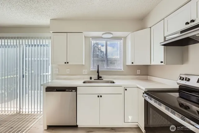a kitchen with a sink stove and cabinets