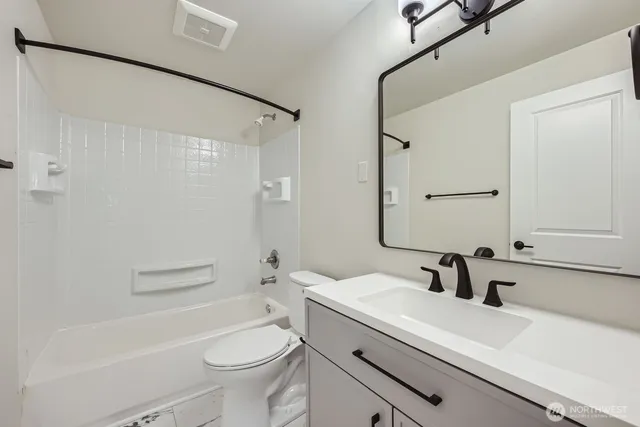 a bathroom with a sink a toilet a mirror and shower