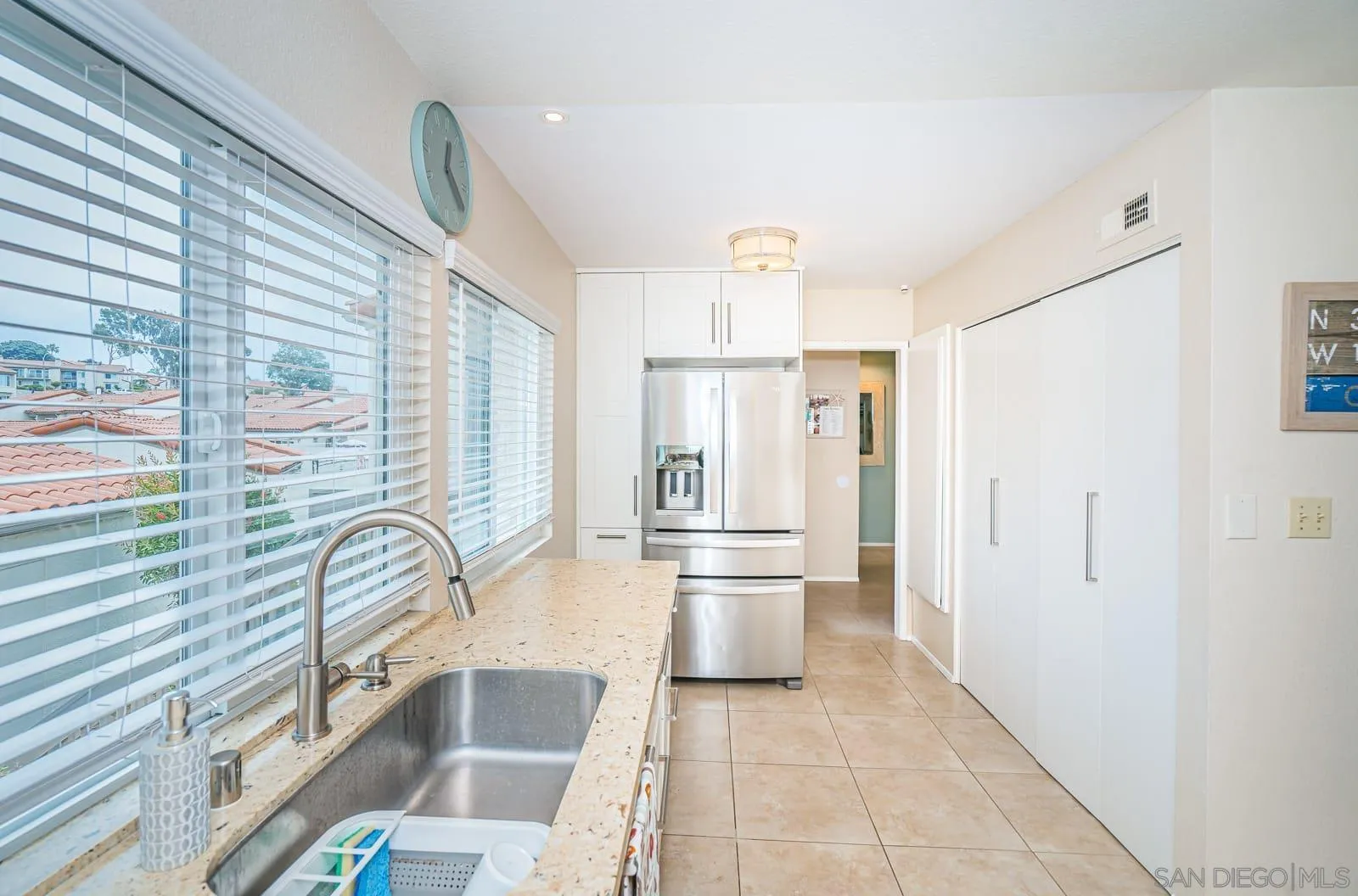 901 Caminito Madrigal, Unit E Carlsbad, CA 92011 - Photo 12 of 28 a kitchen with granite countertop a refrigerator and a sink