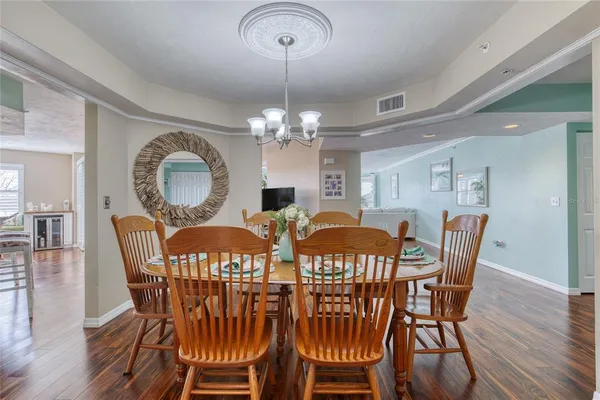 a view of a dining room with furniture wooden floor and chandelier