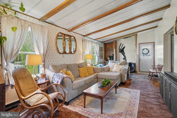 a living room with patio furniture and a wooden floor