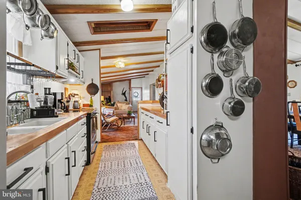 a kitchen with a refrigerator and a wooden floor