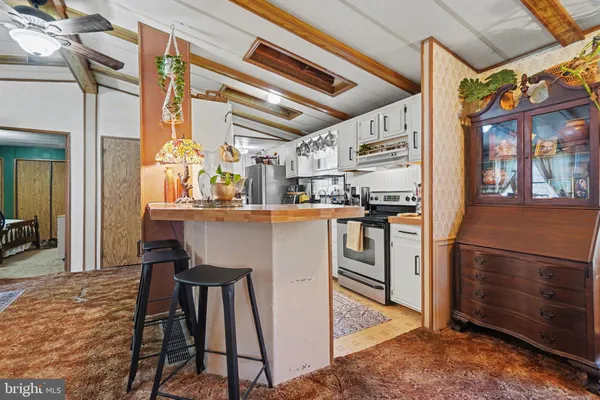 a kitchen with stainless steel appliances kitchen island granite countertop a refrigerator and a stove