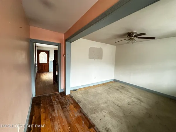 a view of empty room with wooden floor