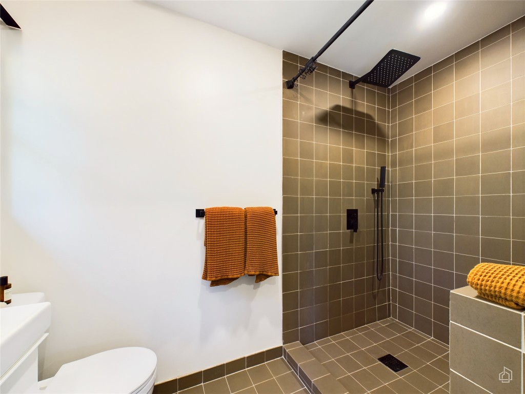 6007 Leisure Run Road Austin, TX 78745 - Photo 13 of 26 a bathroom with a shower a toilet and a sink