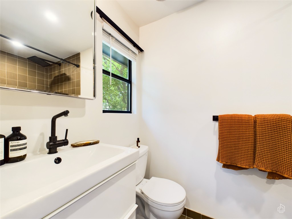 6007 Leisure Run Road Austin, TX 78745 - Photo 14 of 26 a bathroom with a toilet sink and mirror