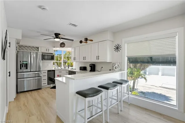 a kitchen with granite countertop a refrigerator and a stove top oven