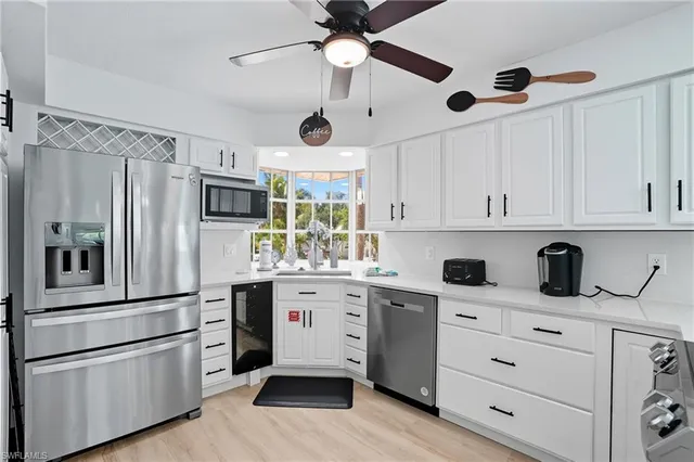 a kitchen with kitchen island white cabinets and stainless steel appliances