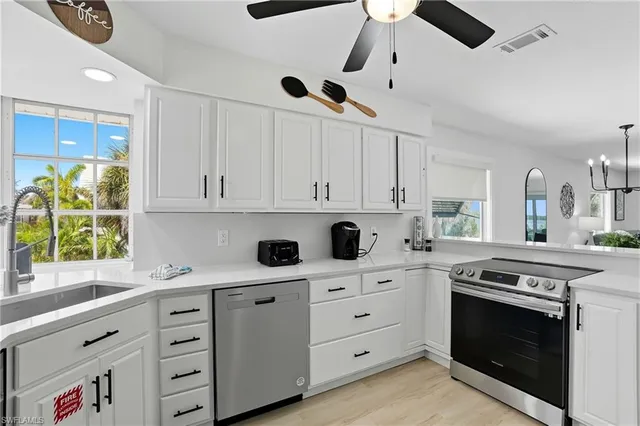 a kitchen with cabinets appliances and a window