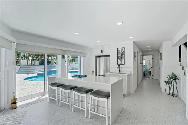a large white kitchen with lots of counter space and furniture