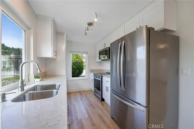 a kitchen with stainless steel appliances granite countertop a refrigerator and a sink
