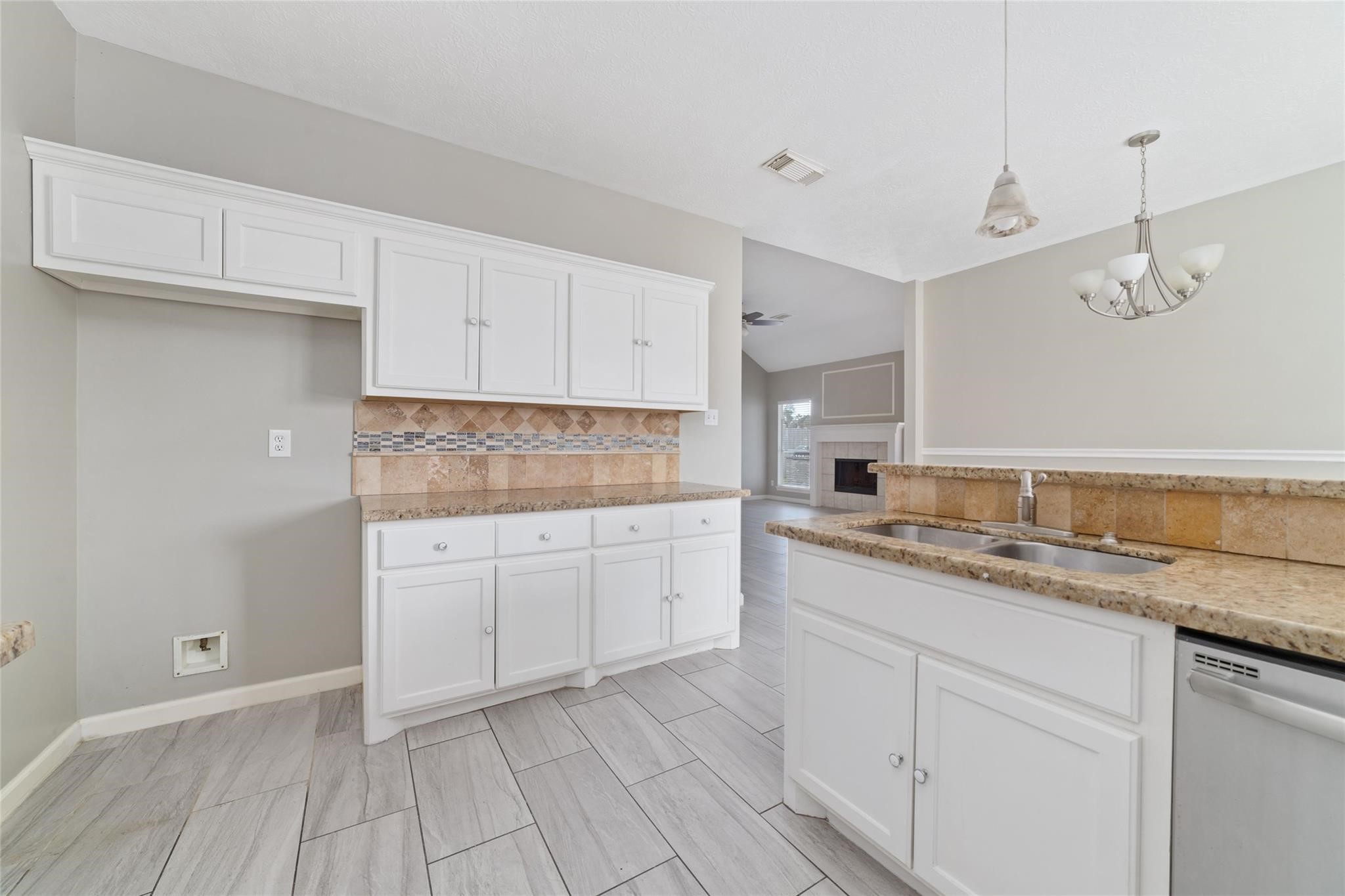 6315 Laurel Run Houston, TX 77084 - Photo 4 of 9 a kitchen with a sink dishwasher and white cabinets with wooden floor