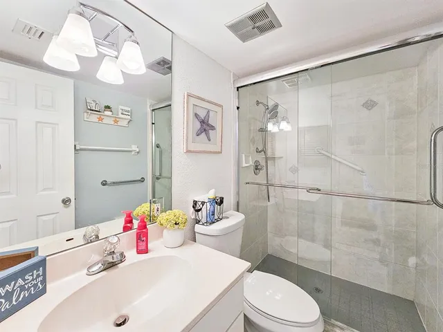 a bathroom with a sink a toilet and shower